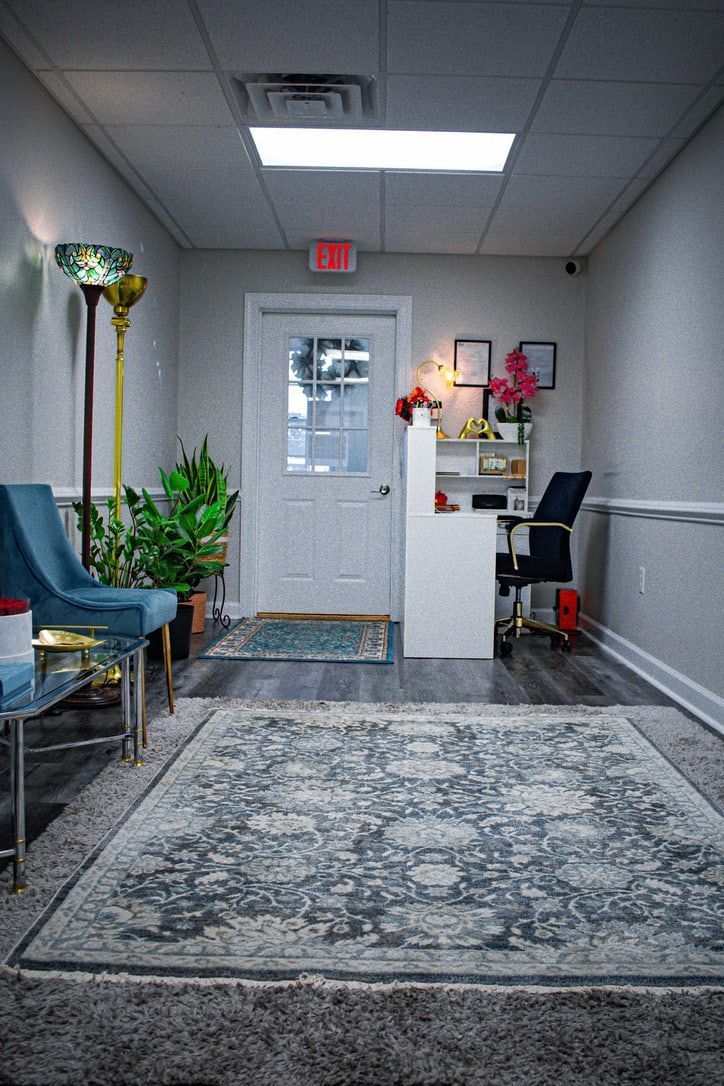 The studio's calm seating area with armchairs, plants, and a soft patterned rug